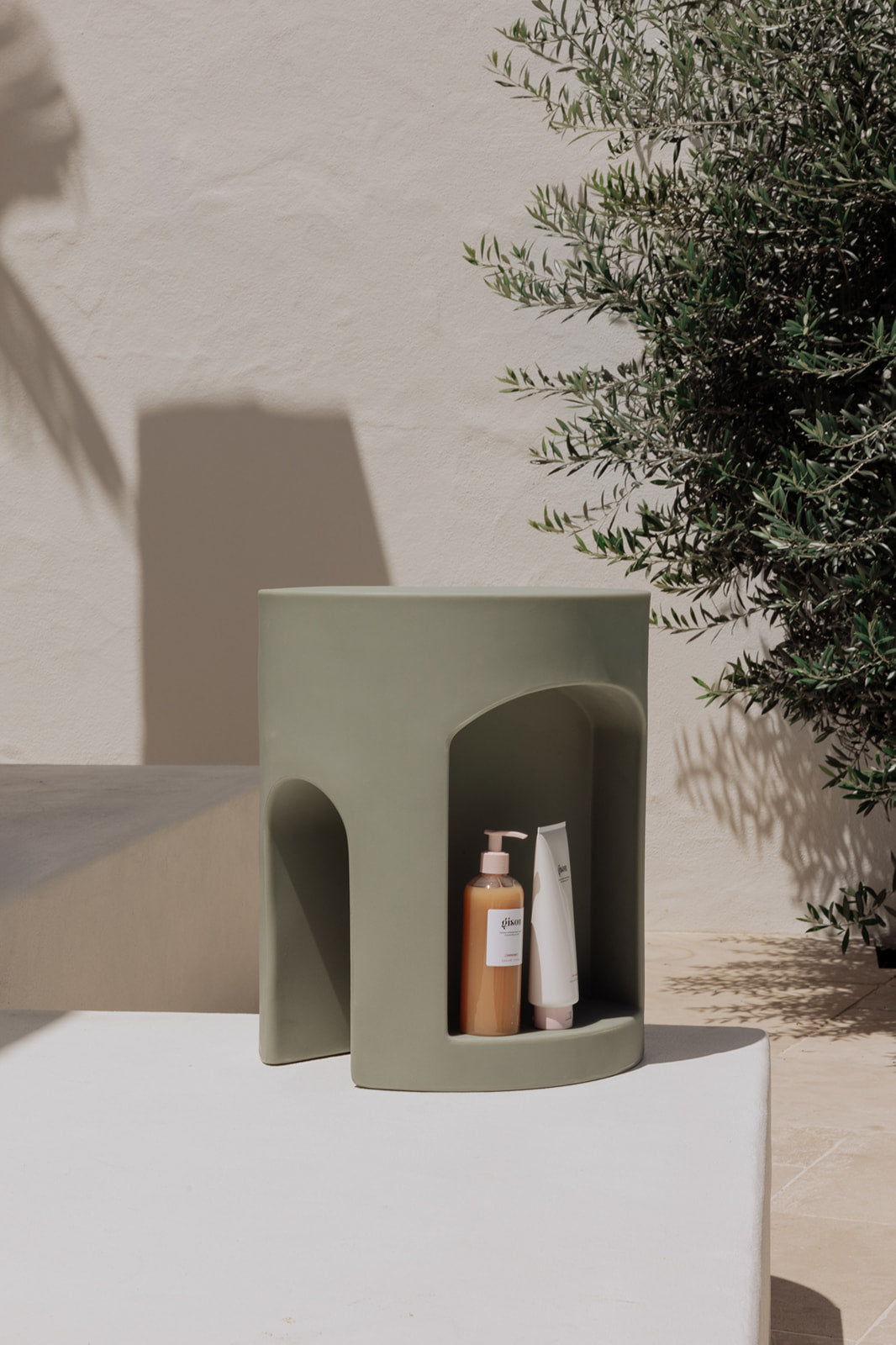 The Smallest Room Chapter One Shower Stool in colour Sage, with Shampoo and Conditioner in the storage area